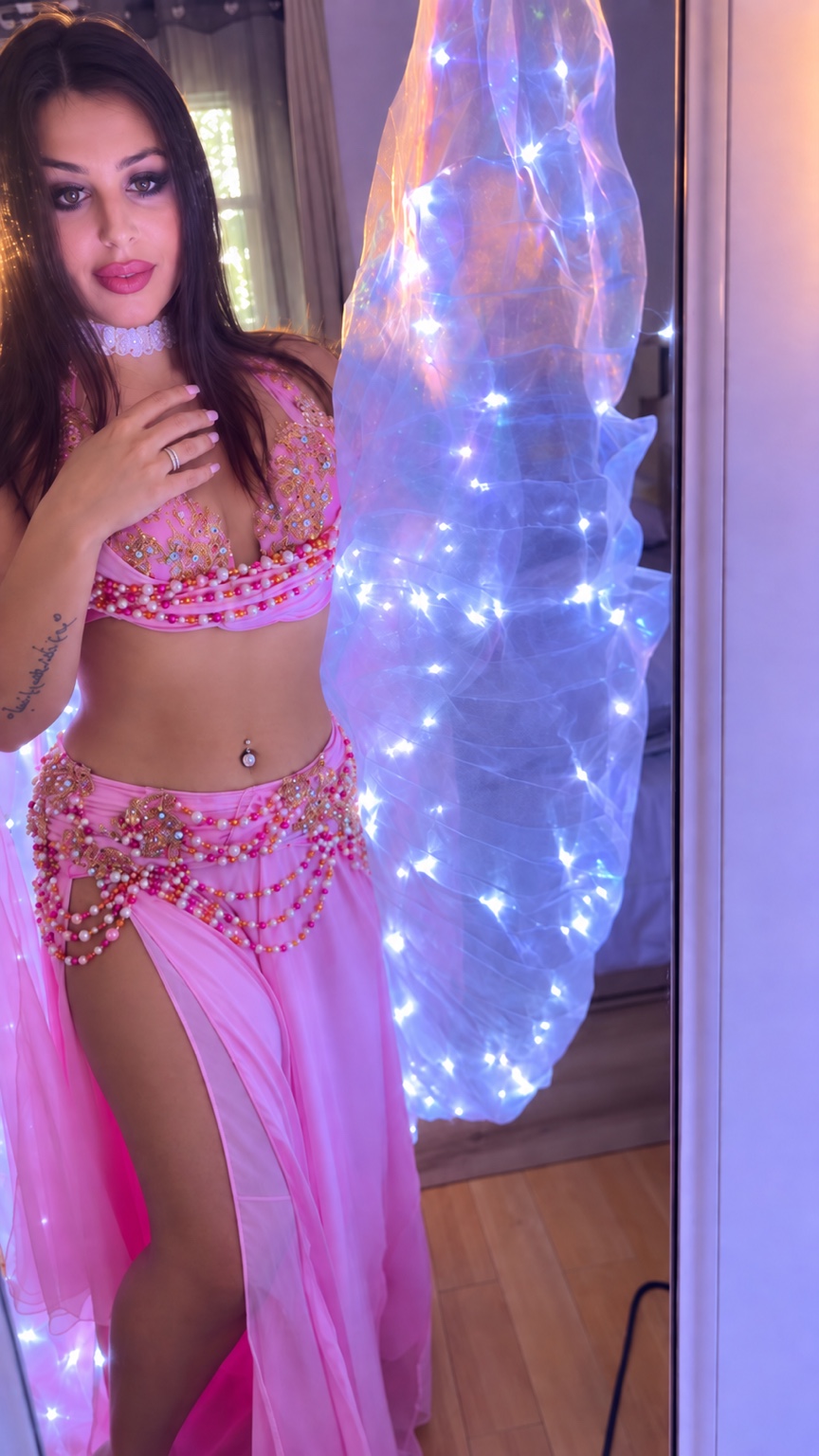 Wassila en costume rose avec ses ailes lumineuses